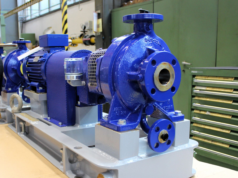 Auf einem Montagetisch in der Fertigungshalle von Apollo steht eine KRC, einstufige Spiralgehäusepumpe. Im Hintergrund sind grüne Werkzeugschränke und ein Kran zu sehen.