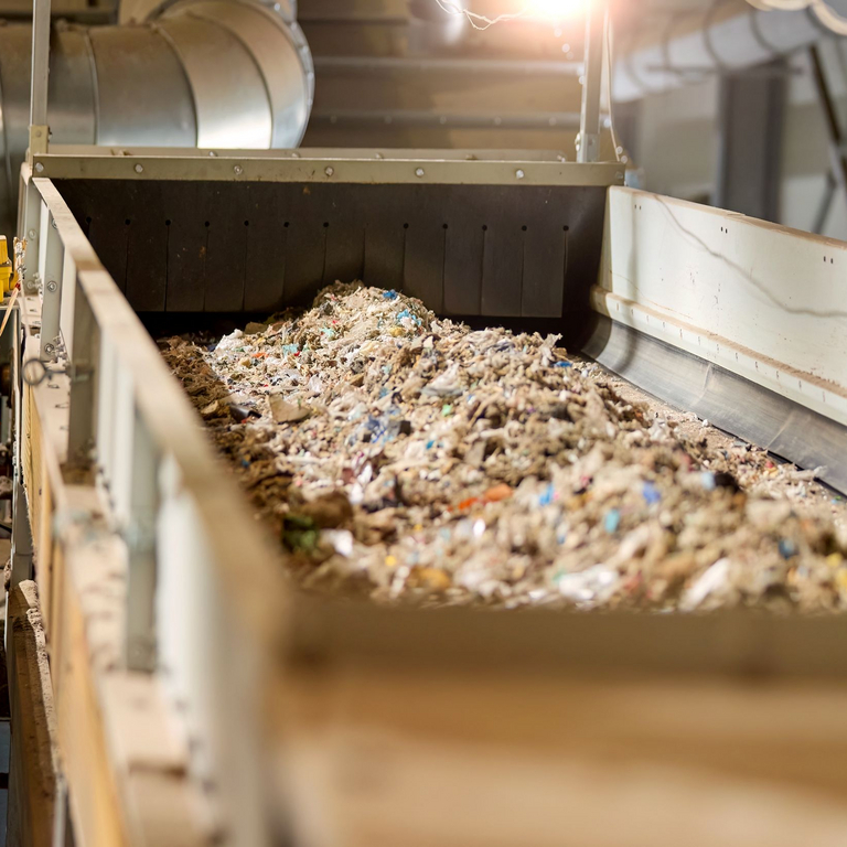 Aus Abfall gewonnener Brennstoff (RDF) auf einem Förderband in einer industriellen Recyclinganlage.