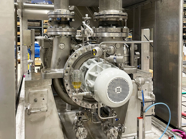 Die frontale Bildaufnahme zeigt eine Schallschutzhaube, in der eine BB2-Pumpe an eine Rohrleitung angeschlossen ist. Die Pumpe durchläuft eine Funktionsprüfung auf dem Apollo-Testfeld.