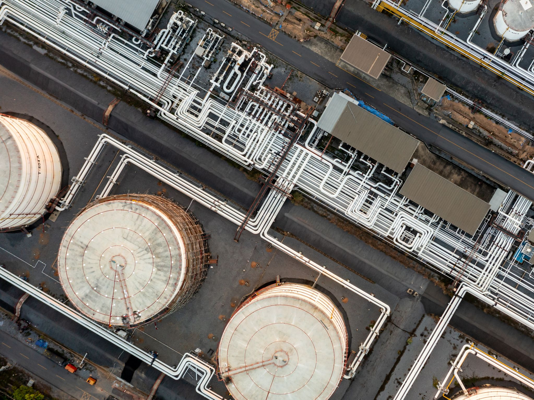 Luftaufnahme eines Öllagertanks und einer Pipeline in einem Industriegebiet für Erdöl.