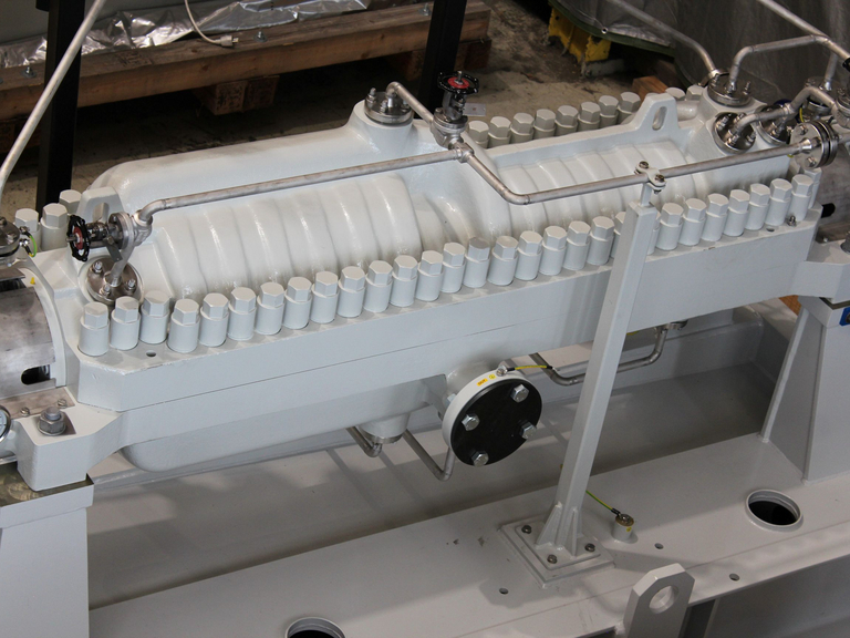 Blick von oben auf das grau lackierte Pumpengehäuse mit den Verschraubungen des axial geteilten Gehäuses in der Fertigungshalle von Apollo Gößnitz. Im Hintergrund sind Werkstattausrüstung und Produktionsumgebung zu sehen.